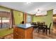 Green dining area featuring vinyl floors, a chandelier, sliding door access to the outside, and wood cabinets at 1007 Windward Hill Ct, Middlesex, NC 27557