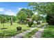 View of long driveway leading to single story home with well-manicured front yard and landscaping at 1007 Windward Hill Ct, Middlesex, NC 27557