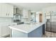 Modern kitchen with white cabinetry, stainless steel appliances, and a gray kitchen island at 101 Cottonwood Ct, Kenly, NC 27542