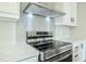 Close up of range hood and kitchen range top with subway tile backsplash at 101 Cottonwood Ct, Kenly, NC 27542