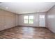 Spacious living room with wood-look vinyl flooring, decorative wall paneling, and plenty of natural light at 101 Cottonwood Ct, Kenly, NC 27542