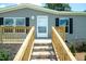 A nice gray home featuring a brick foundation and wooden porch at 103 Cottonwood Ct, Kenly, NC 27542