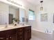 Bright bathroom boasts double sinks, framed mirror, soaking tub, and modern fixtures at 106 Dodge Ln, Smithfield, NC 27577