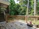 Wooden deck with railing overlooks the lush, private backyard and surrounding wooded area at 106 Dodge Ln, Smithfield, NC 27577