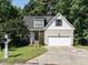 Charming two-story home with a manicured lawn and attached two-car garage and mature trees at 106 Dodge Ln, Smithfield, NC 27577
