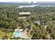 An aerial view reveals a pool, tennis court, lake, clubhouse, and playground nestled among the trees at 115 Baystone Dr, Sanford, NC 27332