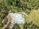 A pool, surrounded by lush trees and lounge chairs, provides a refreshing oasis in this aerial community view at 115 Baystone Dr, Sanford, NC 27332