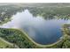 An aerial view reveals a lakefront community, surrounded by lush trees and offering scenic waterfront living at 115 Baystone Dr, Sanford, NC 27332