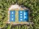An aerial view showcases well-maintained basketball and pickleball courts surrounded by lush, mature trees at 115 Baystone Dr, Sanford, NC 27332