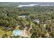 Aerial view of a community pool and clubhouse, surrounded by lush trees and offering lakeside recreation at 115 Baystone Dr, Sanford, NC 27332