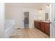 Well-lit bathroom with a large vanity and tile floors, adjacent to the bathtub and doorway to main bedroom at 115 Baystone Dr, Sanford, NC 27332