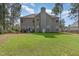Rear exterior view of the home showcasing a spacious backyard with a patio, grill, and lush green lawn at 115 Baystone Dr, Sanford, NC 27332
