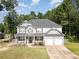 Charming two-story home with a welcoming front porch, well-manicured lawn, and a two-car garage at 115 Baystone Dr, Sanford, NC 27332