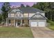 Beautiful two-story home with a covered front porch, manicured lawn, and a two-car garage, exuding curb appeal at 115 Baystone Dr, Sanford, NC 27332