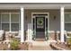 Welcoming front porch with seating, a wreath, and decorative plants at 115 Baystone Dr, Sanford, NC 27332