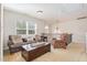 Inviting living room features plush seating, a large window, and a stylish chandelier above the staircase at 115 Baystone Dr, Sanford, NC 27332