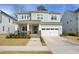 Inviting two-story home featuring a gray exterior, attached two-car garage, and a charming front porch at 1213 Remey Ave, Wake Forest, NC 27587