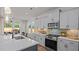 Bright kitchen boasts stainless appliances, gray cabinetry, white countertops, and adjacent breakfast nook at 134 Favored Avenue, Sanford, NC 27330