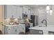 Kitchen featuring gray cabinets, stone backsplash, stainless appliances, quartz countertops, and island sink at 134 Favored Avenue, Sanford, NC 27330