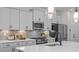 Stylish kitchen with white cabinets, marble countertops, stainless steel appliances, and modern lighting at 134 Favored Avenue, Sanford, NC 27330