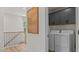 Hallway view of a laundry room featuring a front loading washer and dryer and dark grey cabinets at 134 Favored Avenue, Sanford, NC 27330