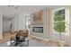 Open-concept living room with a fireplace, hardwood floors, and abundant natural light from large windows at 134 Favored Avenue, Sanford, NC 27330