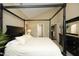 Spacious bedroom featuring a four-poster bed, a dresser with mirror, and ample natural light at 1940 Dunfield Dr, Fuquay Varina, NC 27526
