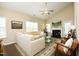 Spacious living room with a fireplace, plush sofa, and a ceiling fan for added comfort at 1940 Dunfield Dr, Fuquay Varina, NC 27526