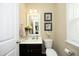 Cozy powder room features a vanity with dark wood cabinets, framed mirror, and decorative artwork at 1940 Dunfield Dr, Fuquay Varina, NC 27526