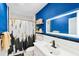 Bathroom showcasing blue accent wall, open shelving and stylish black and gold hardware at 201 N Us 301, Micro, NC 27555