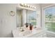 Bathroom featuring double vanity, and large mirror with gold faucet and light fixture at 201 N Us 301, Micro, NC 27555