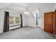 Bright bedroom with a ceiling fan, two windows, gray curtains, and plush gray carpet at 201 N Us 301, Micro, NC 27555