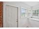 Covered entryway with three windows, shiplap walls, brick accent and white trim and door at 201 N Us 301, Micro, NC 27555