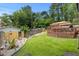 Expansive backyard with lush lawn, mature trees, landscaping, and a charming wooden deck for outdoor living at 2020 Port Royal Rd, Raleigh, NC 27609
