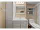 Well-lit bathroom features a toilet, sink and vanity with linen storage at 2020 Port Royal Rd, Raleigh, NC 27609