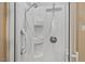Bathroom shower featuring both wall-mounted and hand-held shower heads and white wall panels at 2020 Port Royal Rd, Raleigh, NC 27609