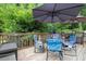 Relaxing deck with multiple seating arrangements and an outdoor umbrella, ideal for enjoying the scenery at 2020 Port Royal Rd, Raleigh, NC 27609