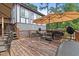 Outdoor deck area offering abundant seating, shade umbrellas, and a tranquil view of the backyard and mature trees at 2020 Port Royal Rd, Raleigh, NC 27609
