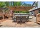Large wooden deck features outdoor seating beneath a shade umbrella, perfect for relaxation and summer dining at 2020 Port Royal Rd, Raleigh, NC 27609