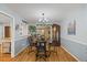 Well-lit dining area featuring blue walls, wood-look floors, a modern chandelier, and decorative accents, creating a welcoming atmosphere at 2020 Port Royal Rd, Raleigh, NC 27609