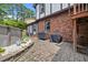 Home exterior with brick, outdoor grills, and a serene patio area with decorative stones, creating a welcoming backyard retreat at 2020 Port Royal Rd, Raleigh, NC 27609