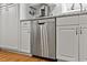 Stainless steel dishwasher is nestled beneath granite countertops and white cabinetry at 2020 Port Royal Rd, Raleigh, NC 27609