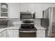 Updated kitchen features stainless steel appliances, white cabinetry, and modern countertops at 2020 Port Royal Rd, Raleigh, NC 27609