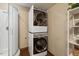 Laundry room with a modern, stacked washer and dryer adjacent to a glass-enclosed shower at 2020 Port Royal Rd, Raleigh, NC 27609