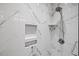 Modern shower with marble-look tiling, rainfall shower head, and built-in shelving niche at 2020 Port Royal Rd, Raleigh, NC 27609