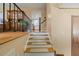 Staircase with carpet runners and a black railing leads to the upper level near a kitchen at 2020 Port Royal Rd, Raleigh, NC 27609