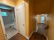 Hallway view featuring a bathroom with tub-shower combo and stairway leading to a white exterior door at 2022 Bivins St, Durham, NC 27707