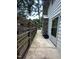 A narrow outdoor walkway with wooden fencing leads to the back entrance near a stone chimney at 2022 Bivins St, Durham, NC 27707