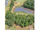 Aerial view of a neighborhood pond, golf course and community with surrounding mature trees at 210 Olde Liberty Dr, Youngsville, NC 27596