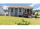Rear exterior of home featuring a screened porch, grill, and lush green lawn at 210 Olde Liberty Dr, Youngsville, NC 27596